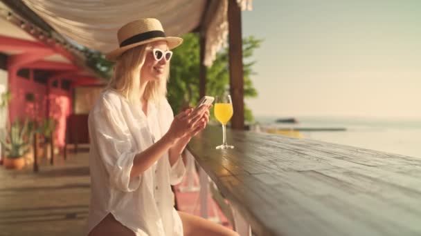 Pozytywna Młoda Blondynka Okularach Przeciwsłonecznych Kapeluszu Pije Rano Lemoniadę Plaży — Wideo stockowe