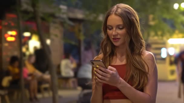 Μια Ελκυστική Νεαρή Γυναίκα Χρησιμοποιεί Κινητό Της Τηλέφωνο Στέκεται Ένα — Αρχείο Βίντεο