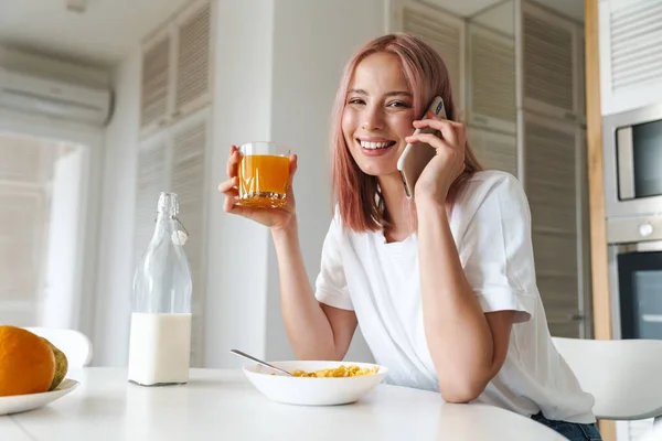 Fénykép Fiatal Örömteli Rózsaszín Hajjal Beszél Mobilon Miközben Reggeli Fehér — Stock Fotó