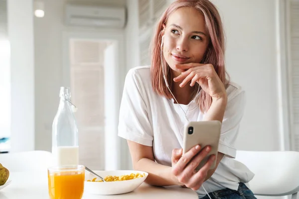 Fénykép Szép Elégedett Mobiltelefon Fülhallgató Használata Közben Reggeli Fehér Konyhában — Stock Fotó