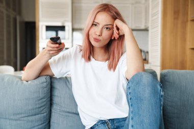 Oturma odasındaki kanepede dinlenen güzel, sıkılmış, çekici bir kadın.