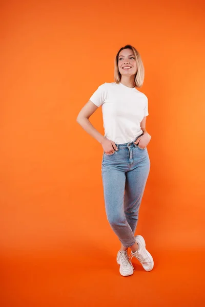 Image Pleased Attractive Woman Smiling Looking Aside Isolated Orange Background — Stock Photo, Image