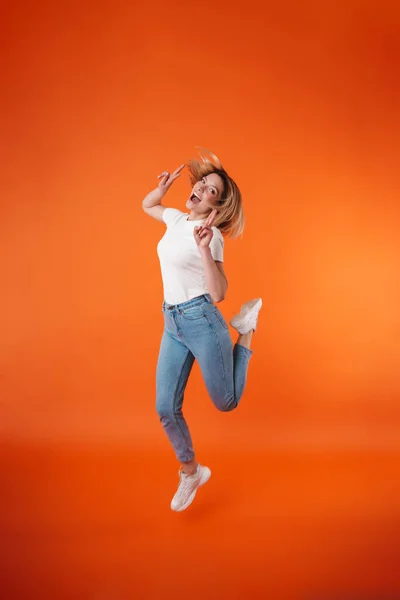 Imagen Mujer Atractiva Alegre Mostrando Signo Paz Mientras Salta Aislado —  Fotos de Stock