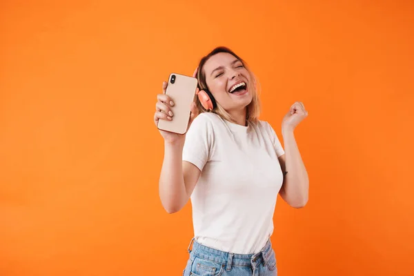 Image Excited Young Woman Dancing Using Cellphone Headphones Isolated Orange — Stock Photo, Image