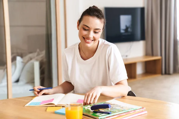 Foto Von Fröhlich Schöne Studentin Lächelnd Während Hausaufgaben Wohnzimmer — Stockfoto