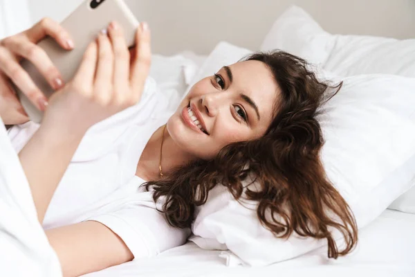 Фото Довольно Веселой Женщины Делающей Селфи Сотовому Телефону Лежащей Кровати — стоковое фото