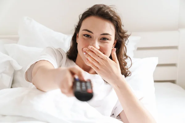 Foto Bella Giovane Donna Gioiosa Con Telecomando Sorridente Mentre Guarda — Foto Stock