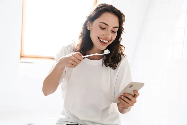 Foto Alegre Hermosa Mujer Sonriendo Limpiando Los Dientes Mientras Usa — Foto de Stock