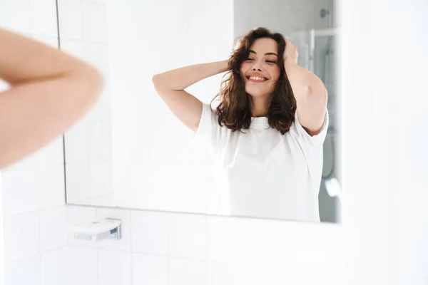 Foto Una Mujer Caucásica Sonriente Agarrando Cabeza Mientras Mira Espejo —  Fotos de Stock