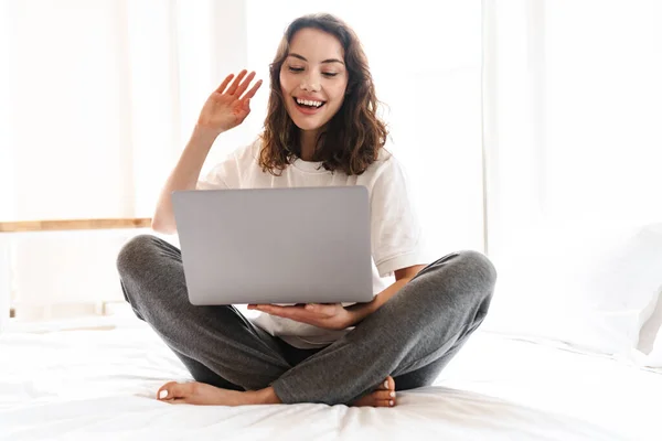 Foto Von Fröhlich Schöne Attraktive Frau Winkt Hand Und Laptop — Stockfoto