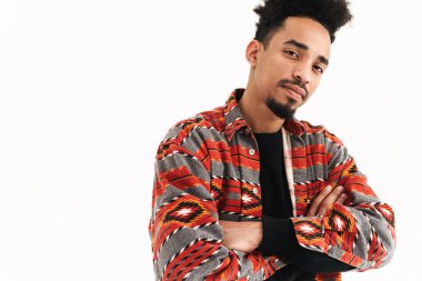 Beyaz duvar arkasında yalnız poz veren yakışıklı Afrikalı genç bir adamın resmi.