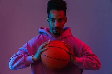 Ciddi bir Afro-Amerikan portresi. Renkli kapüşonlu bir adam. Kameraya bakıyor.