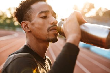 Stadyumda su içen Afrikalı yakışıklı bir genç adamın görüntüsü..
