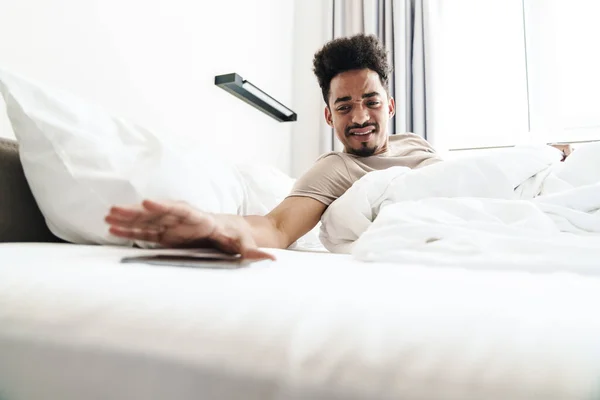 Foto Hombre Afroamericano Disgustado Con Bigote Usando Teléfono Móvil Cama —  Fotos de Stock