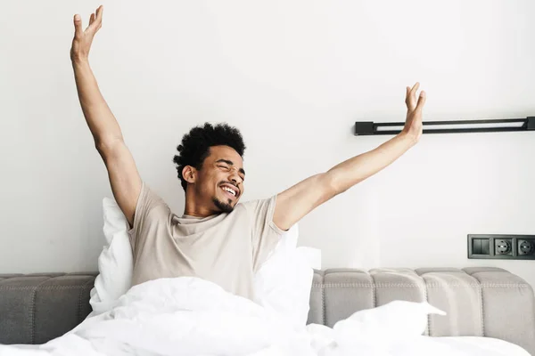 Photo Pleased African American Man Mustache Stretching His Body Bed — Stock Photo, Image