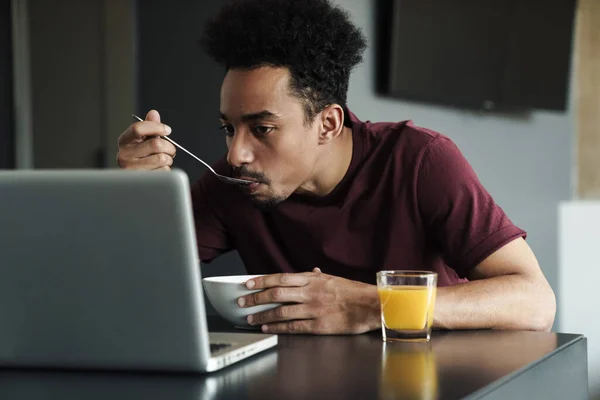 Foto Homem Afro Americano Sério Trabalhando Com Laptop Enquanto Toma — Fotografia de Stock