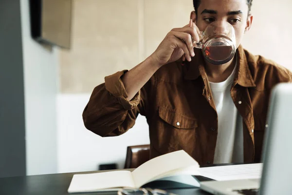 Φωτογραφία Της Σκέψης Αφροαμερικανός Άνδρας Πίνοντας Τσάι Και Χρησιμοποιώντας Φορητό — Φωτογραφία Αρχείου