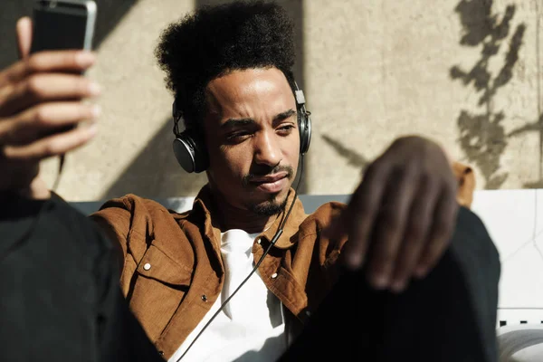 Foto Homem Afro Americano Focado Usando Fones Ouvido Celular Enquanto — Fotografia de Stock