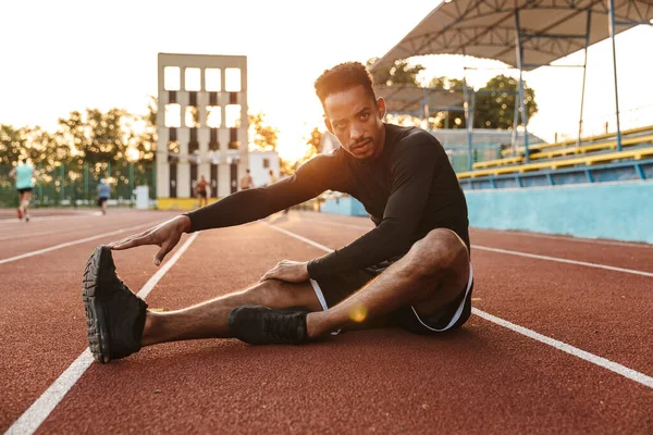 Imagen Del Hombre Afroamericano Concentrado Estirando Cuerpo Mientras Está Sentado —  Fotos de Stock