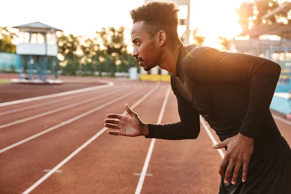 屋外のスポーツ競技場で走るアフリカ系アメリカ人の精力的なイメージ — ストック写真