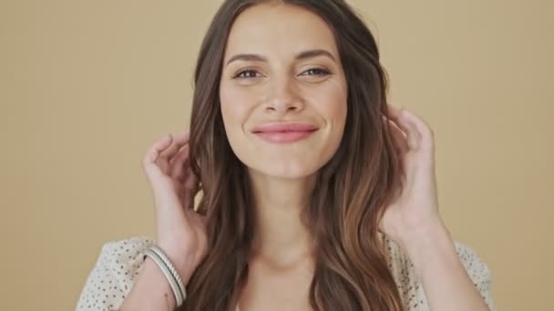 Позитивная Улыбающаяся Молодая Женщина Позирует Перед Камерой Стоящей Бежевом Фоне — стоковое видео