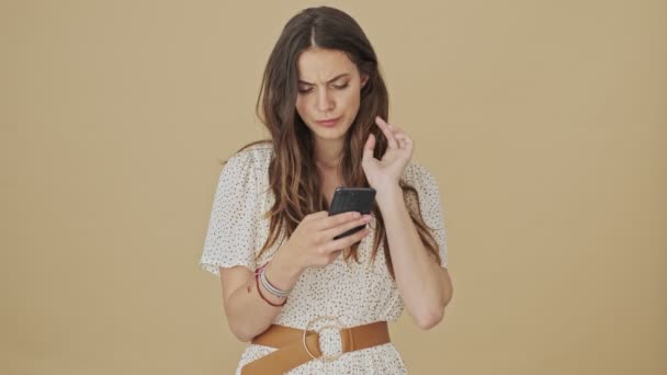 Uma Jovem Focada Seriamente Está Usando Seu Smartphone Sobre Fundo — Vídeo de Stock