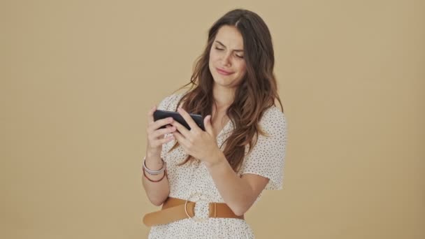 Odaklanmış Genç Bir Kadın Akıllı Telefonundan Bir Şey Izliyor Stüdyoda — Stok video