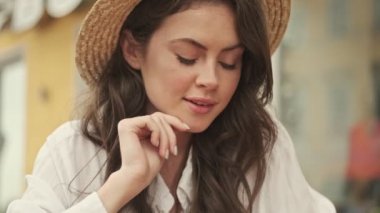 Açık kafedeki masada otururken akıllı telefon kullanan güzel ve çekici bir kadın.