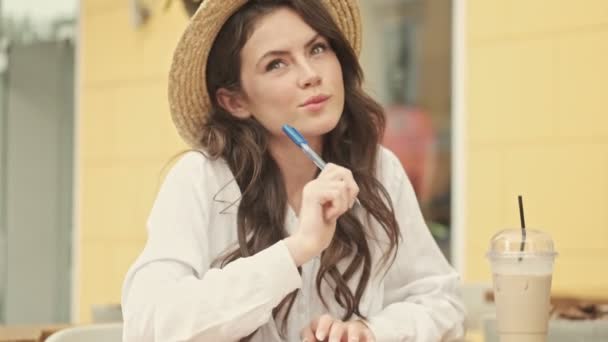 Sonriente Mujer Atractiva Con Sombrero Pensando Algo Luego Escribir Algo — Vídeos de Stock