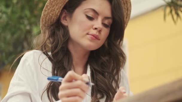 Mulher Atraente Despreocupado Usando Chapéu Escrever Algo Caderno Beber Café — Vídeo de Stock