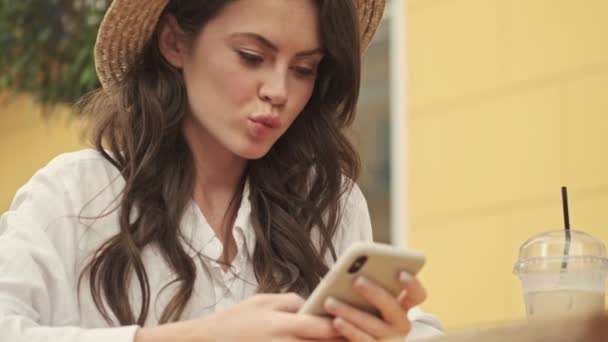 Sorridente Donna Attraente Indossa Cappello Utilizzando Smartphone Mentre Seduto Tavolo — Video Stock