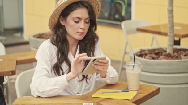 Leende Attraktiv Kvinna Bär Hatt Med Hjälp Smartphone Och Tänker — Stockvideo