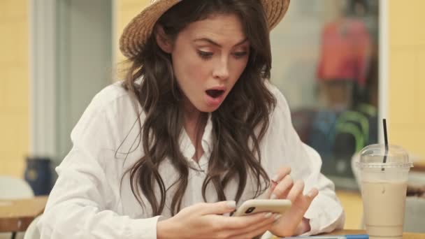 Έκπληκτη Ελκυστική Γυναίκα Φορώντας Καπέλο Χρησιμοποιώντας Smartphone Και Γίνει Ευτυχισμένος — Αρχείο Βίντεο