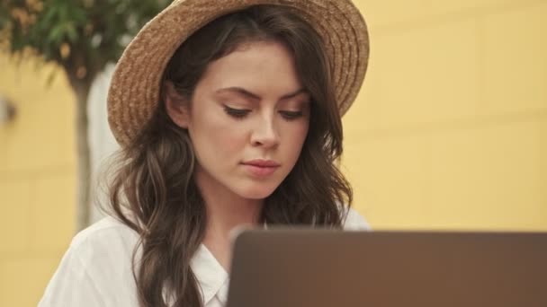 Concentrato Donna Attraente Indossa Cappello Utilizzando Computer Portatile Mentre Seduto — Video Stock