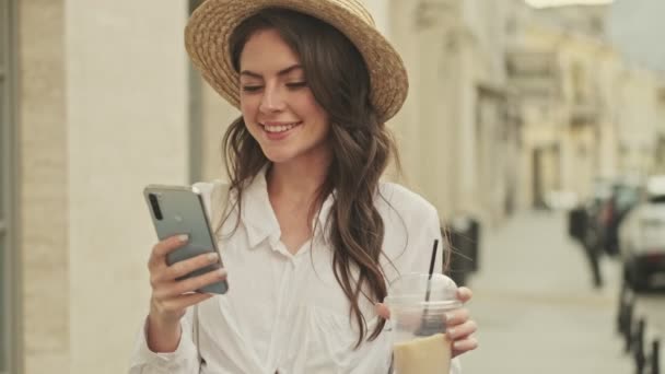 Mulher Atraente Feliz Usando Chapéu Usando Smartphone Beber Café Enquanto — Vídeo de Stock