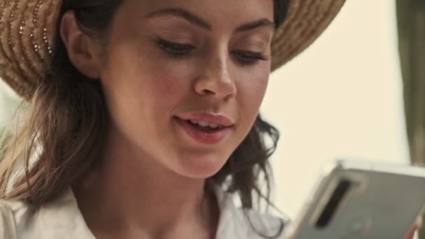 Close Vista Mulher Atraente Sorrindo Usando Chapéu Usando Smartphone Enquanto — Vídeo de Stock