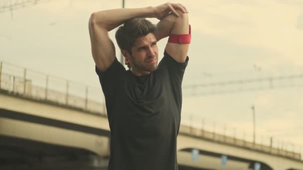 Ένας Μυώδης Άντρας Κάνει Ασκήσεις Που Τεντώνουν Χέρια Του Έξω — Αρχείο Βίντεο