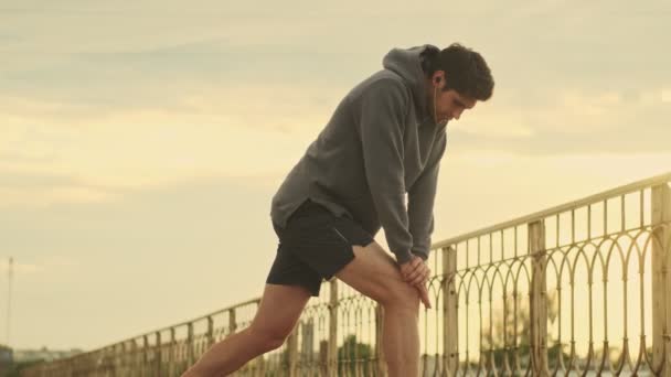 Ein Junger Sportler Mit Kopfhörern Streckt Draußen Der Stadt Seine — Stockvideo