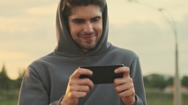 Ein Glücklicher Junger Sportler Beobachtet Etwas Seinem Smartphone Das Waagerecht — Stockvideo
