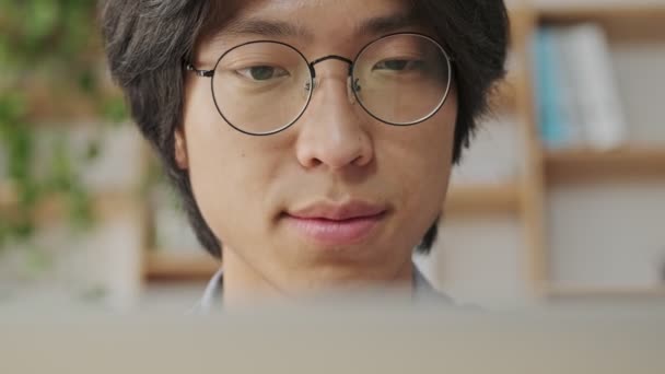 Close View Calm Asian Man Eyeglasses Using Laptop Computer Ενώ — Αρχείο Βίντεο