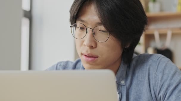 Gözlüklü Dalgın Asyalı Adamın Bir Şey Düşündüğünü Masada Otururken Dizüstü — Stok video