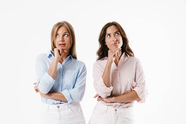 Imagem Pensar Atraente Duas Mulheres Olhando Para Cima Enquanto Posando — Fotografia de Stock