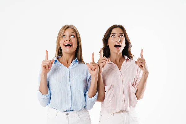 Imagem Duas Mulheres Bonitas Excitadas Apontando Dedos Para Cima Isolado — Fotografia de Stock