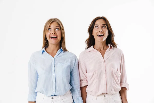 Imagem Duas Mulheres Bonitas Excitadas Sorrindo Olhando Para Cima Isolado — Fotografia de Stock