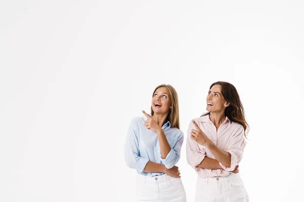 Obrázek Vzrušeného Běloška Dvě Ženy Ukazující Prsty Stranou Usmívající Izolované — Stock fotografie