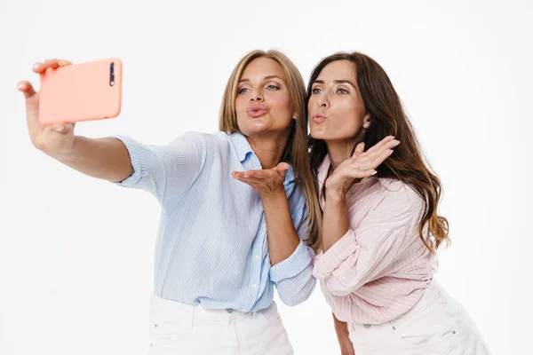 Imagen Dos Mujeres Encantadoras Felices Soplando Beso Aire Tomando Selfie — Foto de Stock