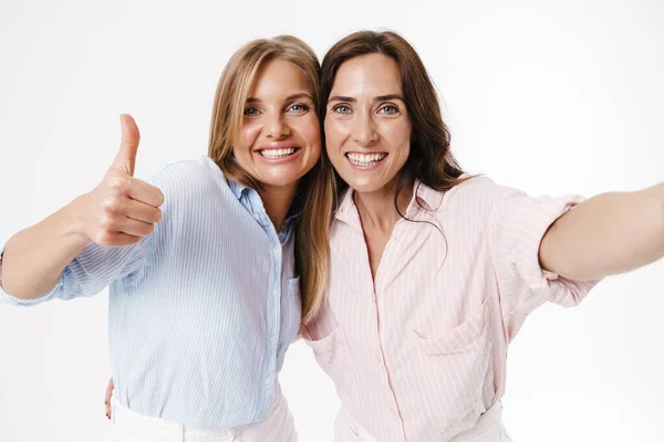 Obrázek Šťastné Dvě Ženy Ukazující Palec Nahoru Při Fotografování Selfie — Stock fotografie