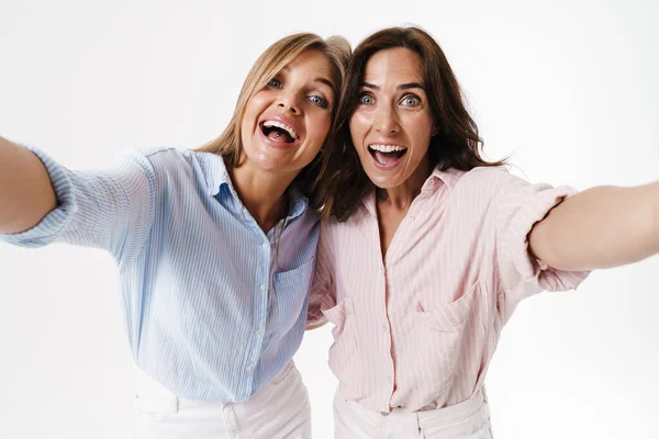 Imagen Dos Mujeres Encantadas Abrazándose Mientras Toman Fotos Selfies Aisladas —  Fotos de Stock