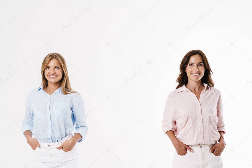 Image of cheerful caucasian two women posing and smiling at camera isolated over white background
