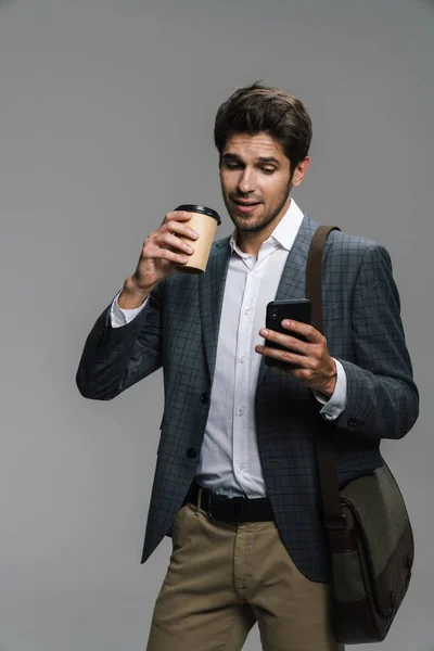 Photo Smiling Confident Businessman Drinking Coffee Takeaway Using Cellphone Isolated — Stock Photo, Image